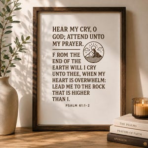 May include: A framed wall art print featuring dark brown text on a white background. The text reads: HEAR MY CRY, O GOD; ATTEND UNTO MY PRAYER. FROM THE END OF THE EARTH WILL I CRY UNTO THEE, WHEN MY HEART IS OVERWHELM: LEAD ME TO THE ROCK THAT IS HIGHER THAN I. PSALM 61:1-2. A circular mountain icon is included.