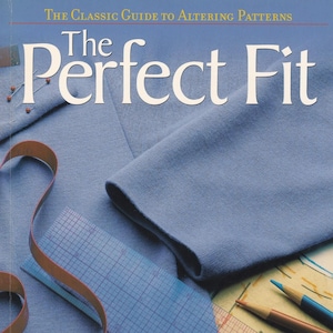 May include: A book titled "The Perfect Fit: The Classic Guide to Altering Patterns" with a blue fabric, a brown measuring tape, a ruler, and pencils on the cover. The book features 400 how-to photographs.