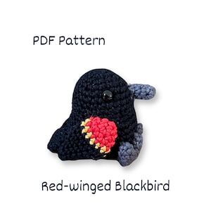 Könnte beinhalten: Ein gehäkeltes Rotflügel-Schwarzvogel mit einem roten und gelben Flügelaufnäher, grauen Flügeln und Füßen sowie einem schwarzen Auge. Der Text "PDF Pattern" und "Red-winged Blackbird" werden angezeigt.
