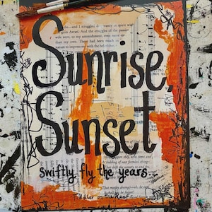 May include: Mixed media artwork with the words "Sunrise, Sunset" in large black lettering. The background features sheet music, orange paint strokes, and handwritten text. Paintbrushes and markers are visible.