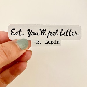 May include: White sticker with black text that reads "Eat. You'll feel better. -R. Lupin".