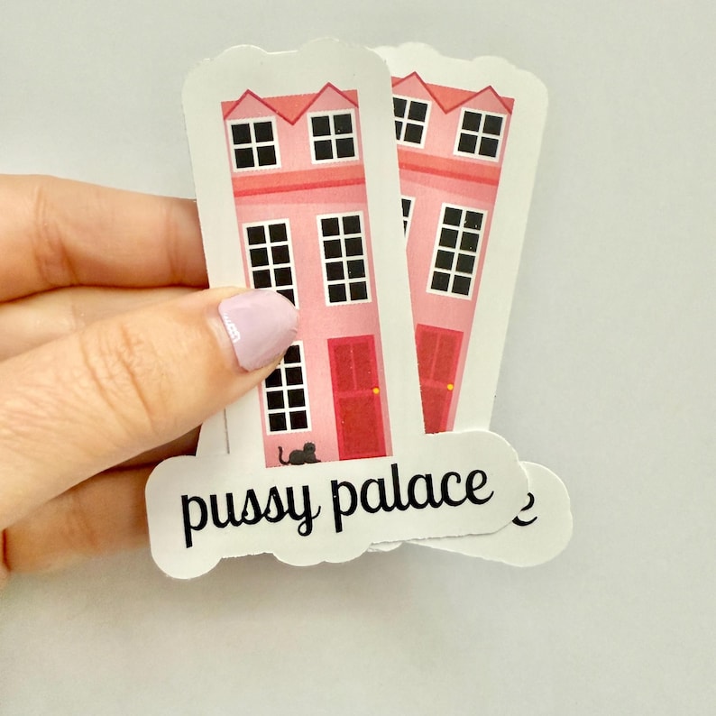 May include: Pink house stickers with black windows, red doors, and a black cat silhouette. The stickers have the words "pussy palace" in black script.