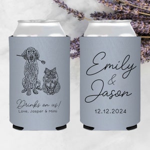 May include: Two gray can coolers with black text. One cooler features a line drawing of a dog and cat with the text "Drinks on us! Love, Jasper & Mimi". The other cooler has the text "Emily & Jason 12.12.2024".