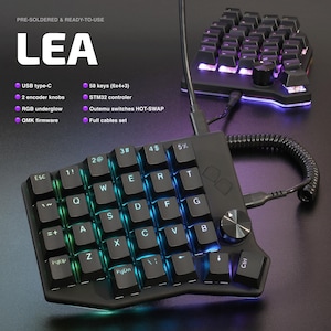Könnte beinhalten: Schwarze ergonomische Tastatur mit RGB-Hintergrundbeleuchtung und 58 Tasten. Merkmale sind USB Typ-C, 2 Encoder-Knöpfe und Hot-Swap-Schalter von Outemu. Die Tastatur ist vorverlötet und einsatzbereit. Der Text "LEA" wird angezeigt.