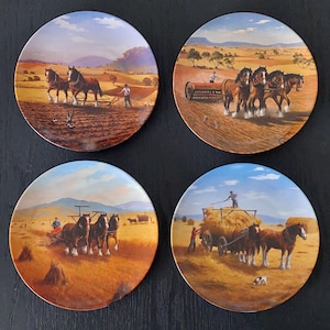 May include: Four decorative plates depicting rural scenes. Each plate shows a different farming activity with horses, farmers, and machinery. The plates have a gold rim and are set against a black background.