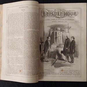 May include: An open book with the title "THE LEISURE HOUR" on the top left page and a detailed illustration on the right page. The illustration depicts three men in a room, with text below reading "STRUGGLES IN LIFE".