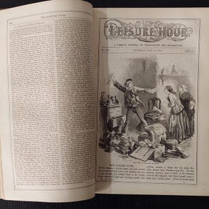 May include: An open book with illustrations and text. The right page features a detailed black and white illustration of a scene with figures, furniture, and scattered objects. The title "THE LEISURE HOUR" is visible at the top.