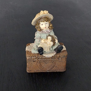 Fille vintage avec poupée sur une boîte à bijoux,