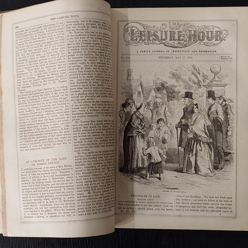 May include: An open book with a black and white illustration of a group of people in period clothing. The title "The Leisure Hour" is at the top, with text below. The page is from a historical publication.