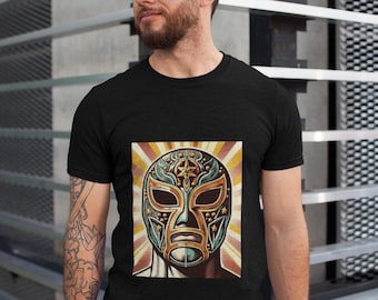 Peut inclure: Un t-shirt noir avec une illustration de style vintage d'un masque de luchador. Le masque est vert, or et noir avec un motif d'étoile. L'arrière-plan est un dégradé radial jaune et orange.