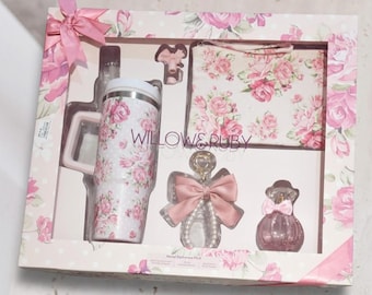 May include: A gift set featuring a floral-patterned tumbler, small purse, perfume bottle, and decorative item, all in a pink and white color scheme. The set is presented in a decorative box with a matching floral design and pink ribbon accents. The brand name "WILLOW & RUBY" is visible.