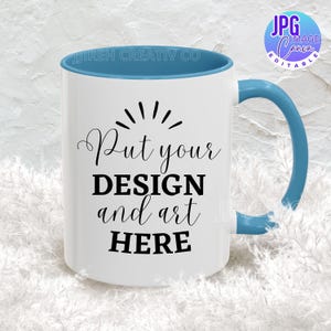 May include: White ceramic mug with a blue rim and handle. The mug has the text "Put your DESIGN and art HERE" printed on it.