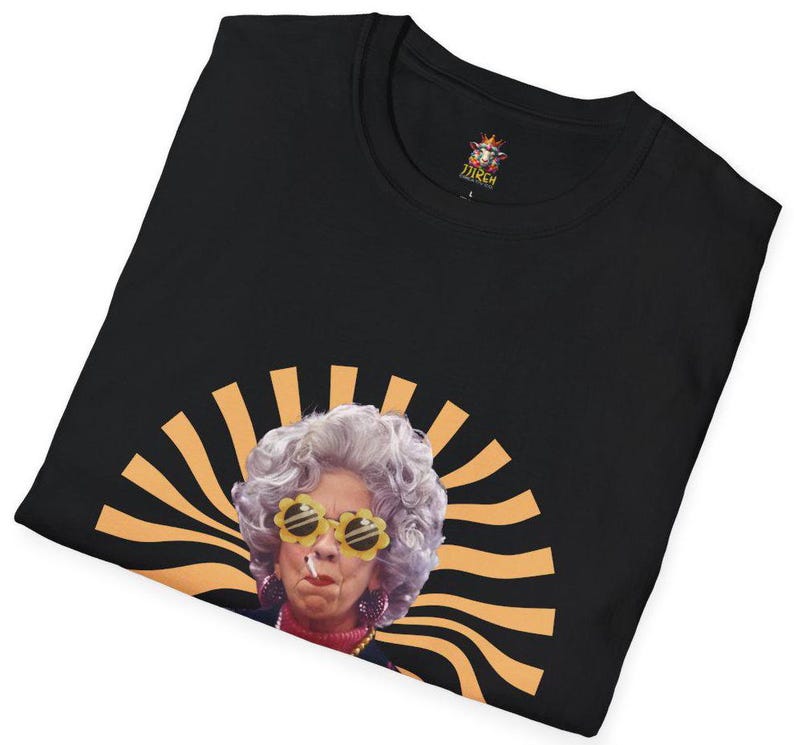 May include: Black t-shirt with a retro-style image of a woman wearing sunglasses and a cigarette. The image is surrounded by orange and yellow stripes.