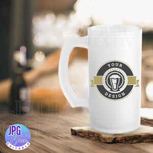 May include: White ceramic beer stein with a black and gold logo that says "Your Design" and features a silhouette of a beer glass. The stein has a large handle.