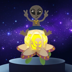 May include: A whimsical alien figure with a peace sign necklace, seated on a glowing, flower-shaped craft. The craft has a yellow interior and an alien silhouette. The background is a starry night sky.