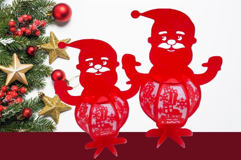 May include: Two red Santa Claus lanterns with a festive design. The lanterns have a round, patterned body and a Santa Claus head. Christmas decorations, including ornaments and stars, are in the background.