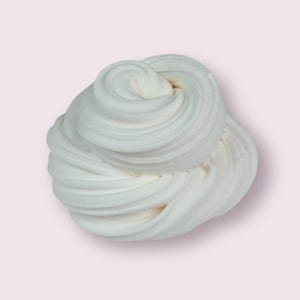May include: A swirl of white slime against a light pink background. The slime has a soft, creamy texture with visible ridges and a slight off-white hue. The image is well-lit, highlighting the texture and form of the slime.