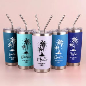 May include: Five stainless steel tumblers with lids and straws. Each tumbler has a different color: teal, light blue, white, dark blue, and navy. Each tumbler features a palm tree design and a name with "San Diego 2026" text.