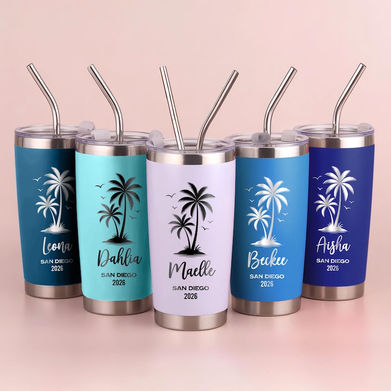 May include: Five stainless steel tumblers with lids and straws. Each tumbler has a different color: teal, light blue, white, dark blue, and navy. Each tumbler features a palm tree design and a name with "San Diego 2026" text.
