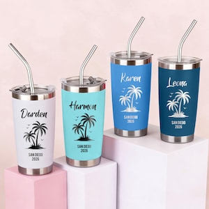 Puede incluir: Cuatro vasos de acero inoxidable con tapas y pajitas. Cada vaso es de un color diferente: blanco, turquesa, azul y azul marino. Cada uno tiene un nombre y un gráfico de palmera con el texto "SAN DIEGO 2026".