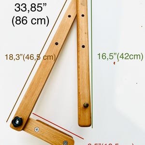 Wooden foldable Mahl stick , unfolded measures 33.85' (86cm) and folded measures 17.71' (45cm).  When unfolded, the height is 18.3' (46.5cm) and the width is 16.5' (42cm). Folded dimensions are 6.5' (16.5cm) in width.  The light brown wooden Mahlstick has small knobs and holes for adjustments.  Ideal for artists and crafters.