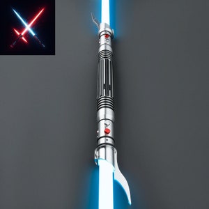 May include: A silver lightsaber with a blue blade. The lightsaber has a black handle with red buttons and a silver hilt.
