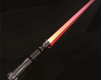 May include: A silver lightsaber with a red blade. The lightsaber is turned on and the blade is glowing.