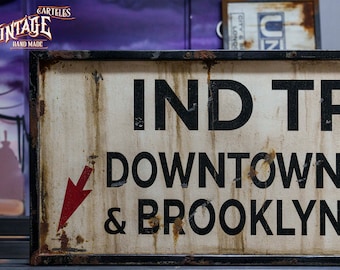 May include: Vintage metal sign with a red arrow pointing to the right. The sign reads "IND TRA DOWNTOWN & BROOKLYN".