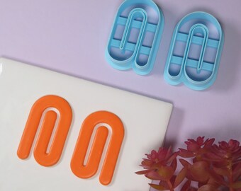 May include: Two blue plastic cookie cutters shaped like the letter "n" and two orange fondant cutouts shaped like the letter "n".