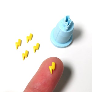 May include: A set of five yellow lightning bolt shaped fondant decorations and a blue plastic mold for making fondant lightning bolts.