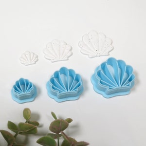以下が含まれることがあります： 青と白のプラスチック製の貝殻型クッキーカッター6個セット。カッターは様々なサイズで、一番大きいカッターは約10cm幅です。