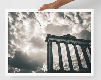 May include: A black and white photograph of an ancient Roman temple with tall columns. The sky is cloudy and dramatic.