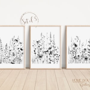 May include: Set of three black and white watercolor prints featuring abstract floral designs. The prints are framed in natural wood frames and have a white background. The text "Set of 3" is visible in the top center of the image.