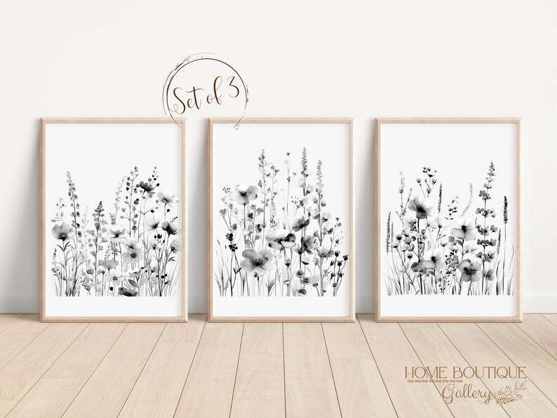 May include: Set of three black and white watercolor prints featuring abstract floral designs. The prints are framed in natural wood frames and have a white background. The text "Set of 3" is visible in the top center of the image.
