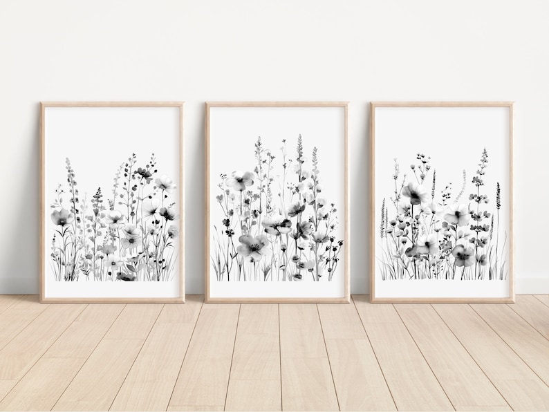 May include: Set of three black and white framed prints featuring a watercolor style illustration of a field of wildflowers.