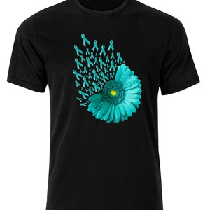 Könnte beinhalten: Ein schwarzes T-Shirt mit einer türkisblauen Blume und türkisblauen Bändern. Die Bänder sind in einem wirbelnden Muster um die Blume angeordnet.