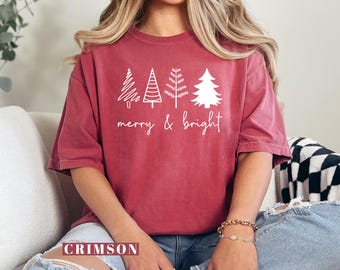 May include: A crimson red t-shirt with a white graphic of four stylized Christmas trees and the text "merry & bright".