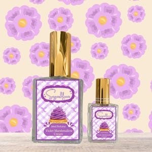 May include: Two perfume bottles with gold caps. The labels read "Sugarbloom" and "30ml Perfume Violet Marshmallow Cream" with a cupcake graphic. The background is a floral pattern with purple flowers.
