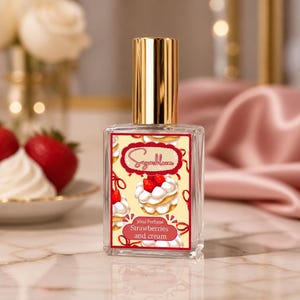 May include: A clear glass perfume bottle with a gold cap. The label features a dessert design with strawberries and cream, and the text "Sugarbloom" and "Strawberries and cream". The bottle contains 30ml of perfume.