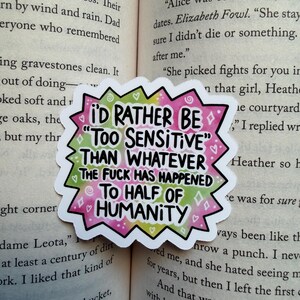 May include: A die-cut sticker with a jagged, starburst-shaped border featuring a tie-dye pattern of pink, green, and white. The sticker displays the black text: I'D RATHER BE "TOO SENSITIVE" THAN WHATEVER THE FUCK HAS HAPPENED TO HALF OF HUMANITY.