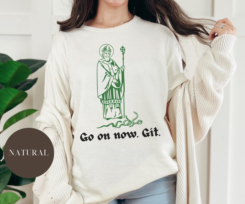 May include: A white sweatshirt with a green illustration of a man with a beard and a snake. The text "Go on now. Git." is printed below the illustration.