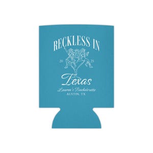 K&ouml;nnte beinhalten: Ein hellblauer Getr&auml;nkedosenk&uuml;hler mit dem Text "Reckless in Texas" und einer Grafik von Frauen, die auf einem Martini-Glas reiten. Der Text "Lauren's Bachelorette Austin, TX" ist ebenfalls enthalten.