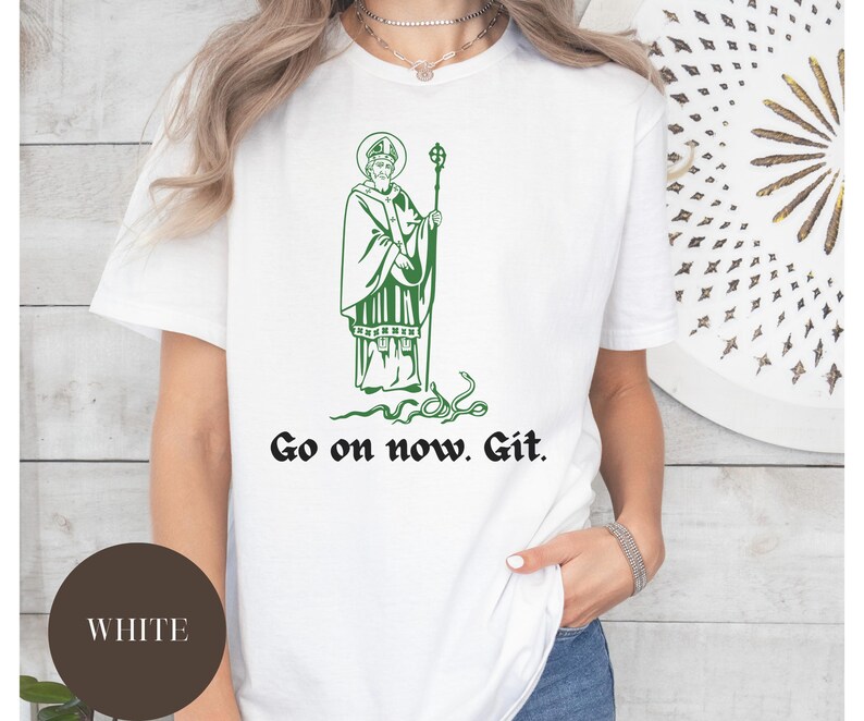 May include: White t-shirt with a green illustration of a man with a beard and a halo, holding a staff. The text "Go on now. Git." is printed below the illustration.