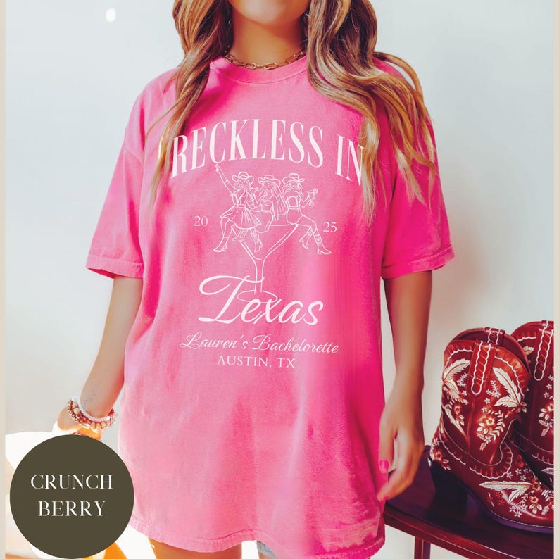 K&ouml;nnte beinhalten: Rosafarbenes Oversize-T-Shirt mit wei&szlig;em Text, der "Reckless in Texas" lautet, mit einer Grafik von vier Frauen, die auf einem Martini-Glas sitzen. Der Text "Lauren's Bachelorette Austin, TX" ist ebenfalls auf dem Shirt aufgedruckt.