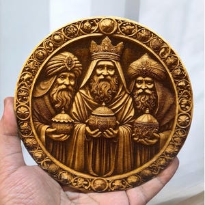 May include: A round wooden plaque with a carved image of the three wise men. The men are depicted in ornate robes and holding gifts. The plaque is surrounded by a decorative border.