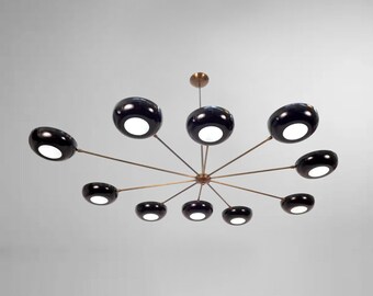 May include: A modern, brass and black chandelier with ten round, black shades. The chandelier has a starburst design with the shades extending outward from a central point.