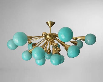 May include: A gold-toned chandelier with multiple turquoise glass globes. The chandelier has a starburst design with the globes extending outward from a central point.