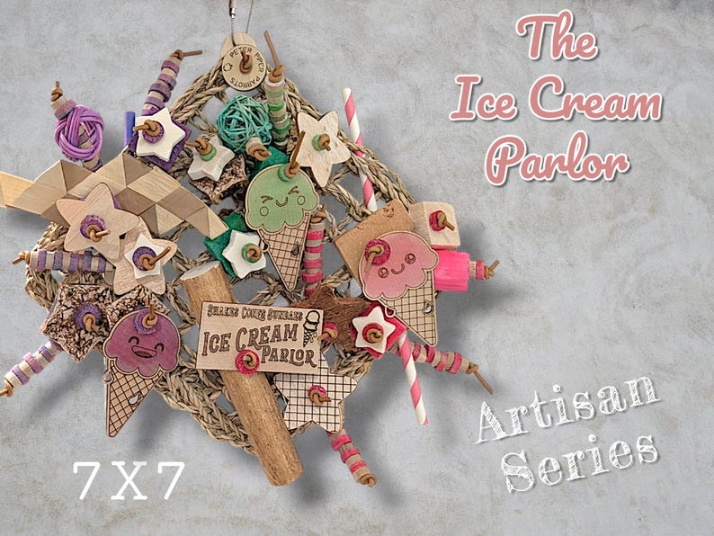 May include: A hanging bird toy featuring a woven square base adorned with wooden ice cream cone cutouts, stars, and colourful beads. The toy includes a sign reading The Ice Cream Parlor and measures 17.8x17.8 cm, designed for avian enrichment.
