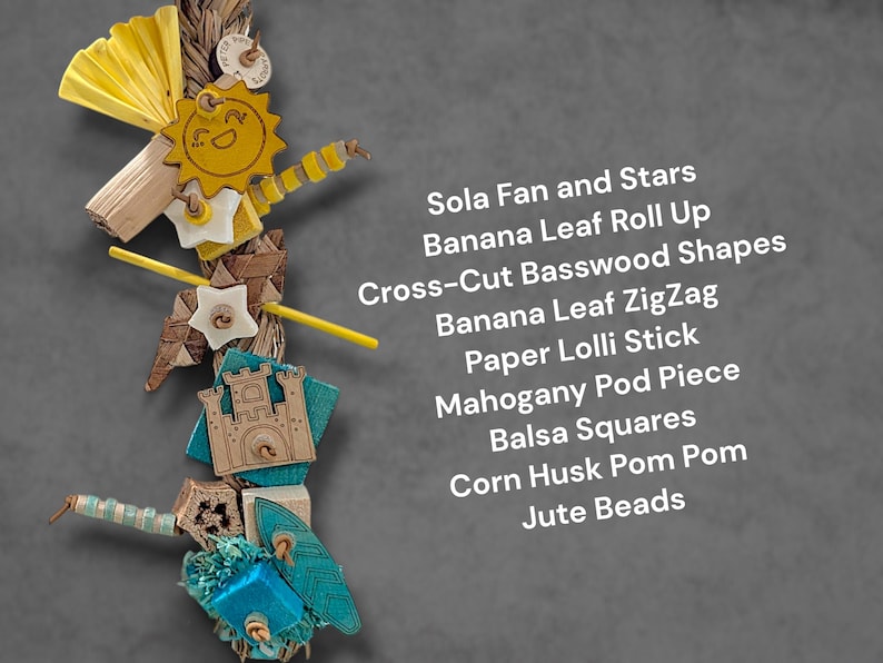 May include: A bird toy featuring a vertical arrangement of Sola fan and stars, banana leaf roll up, cross-cut basswood shapes, banana leaf zigzag, paper lolli stick, mahogany pod piece, balsa squares, corn husk pom pom, and jute beads on a rope.