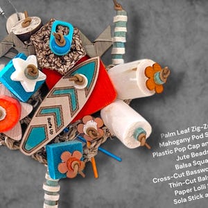 May include: A multi-textured bird toy featuring a central wooden surfboard shape with the text Surf's Up, surrounded by palm leaf zig-zags, mahogany pod slices, plastic pop caps, jute beads, balsa squares, cross-cut basswood, and sola sticks.